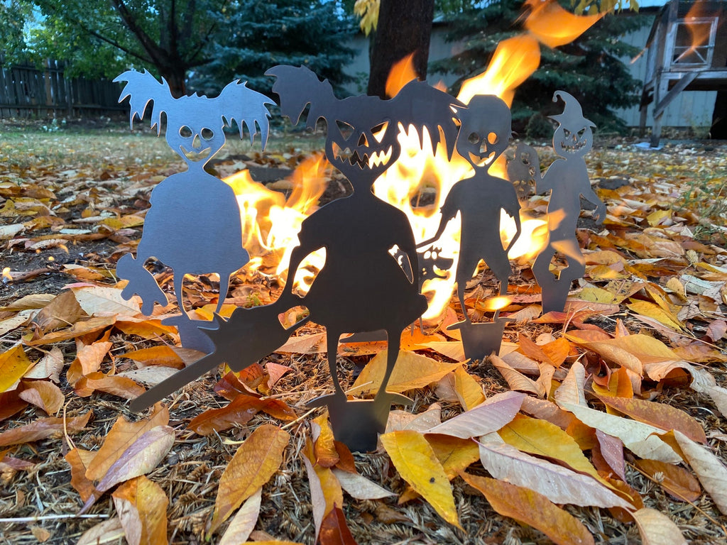 Silhouettes of skeletons around a campfire with autumn leaves on the ground