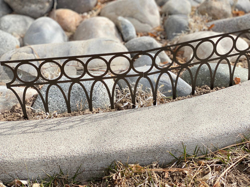 Black powder coated metal garden fence panel featuring Gothic pointed arches and decorative scrollwork with integrated ground stakes