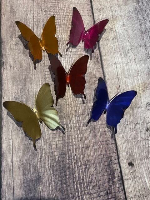 Set of five colorful powder-coated metal monarch butterflies with dimensional wing details arranged for wall display.