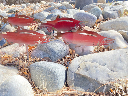 Red fish cutouts on a rocky surface